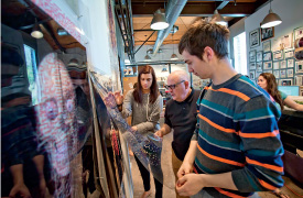 Leslie Tintle ’16 (L-R), Prof. Kerns, Ben Williamson ’16, and Allison Reich ’15 review artwork.