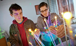 Ben Williamson ’16 (left) and Scott Kovacs, a  part-time student, adjust lights and wiring for one  of the venue sets.