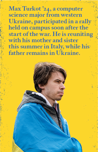 Max Turkot '24 stands wrapped in a Ukrainian flag. The computer science major from western Ukraine participated in a rally held on campus soon after the start of the war. He is reuniting with his mother and sister this summer in Italy, while his father remains in Ukraine.