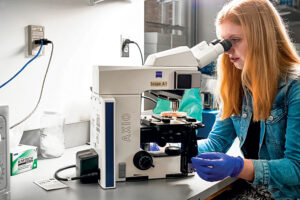 Samantha Ganser '23 looks into a microscope